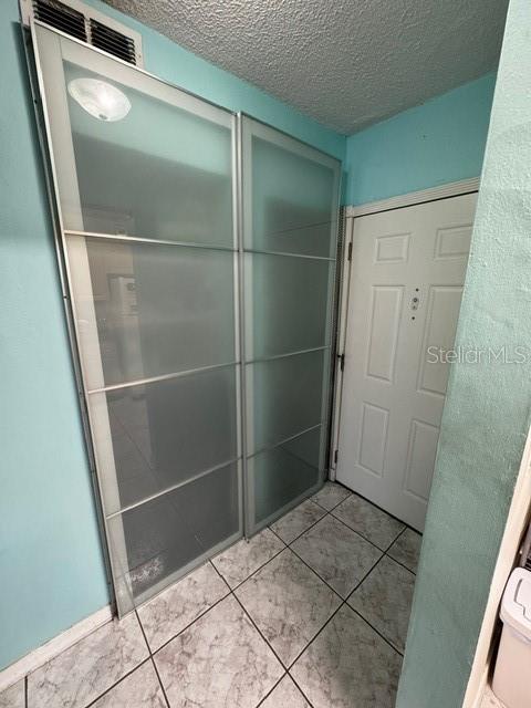 bathroom featuring tile patterned floors and a textured ceiling