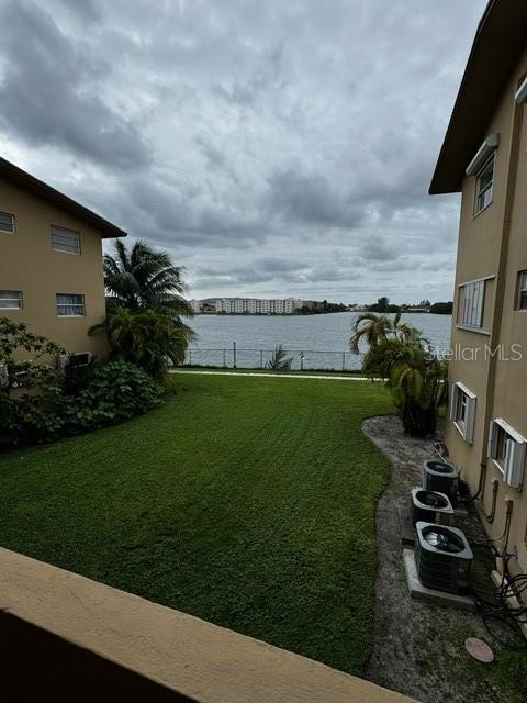 view of yard with a water view and central air condition unit