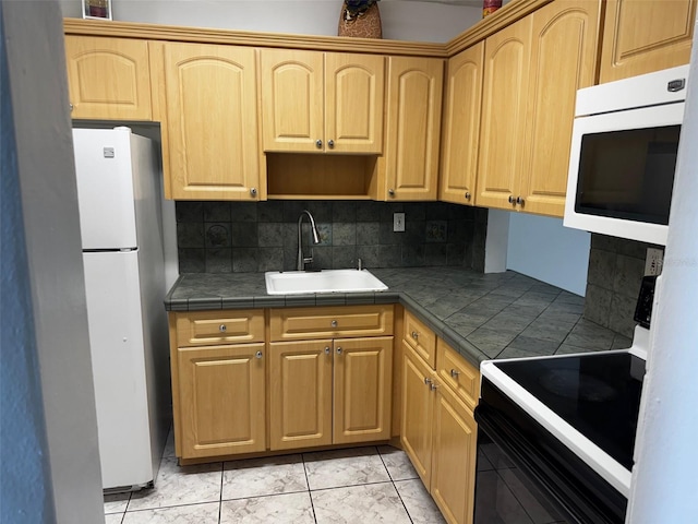 kitchen featuring tile countertops, white appliances, light brown cabinets, and a sink