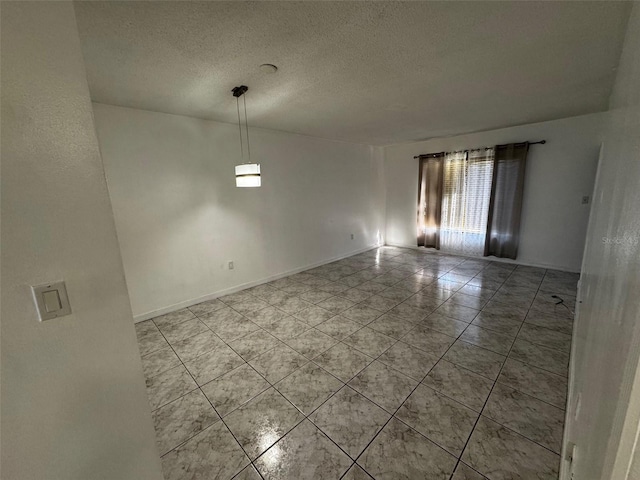 unfurnished room featuring a textured ceiling, baseboards, and light tile patterned floors