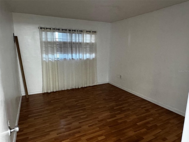 unfurnished room with wood finished floors and baseboards