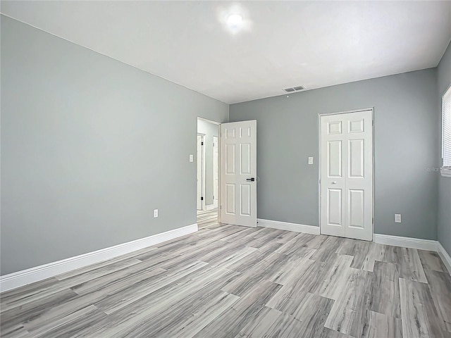 unfurnished bedroom with light hardwood / wood-style floors and a closet