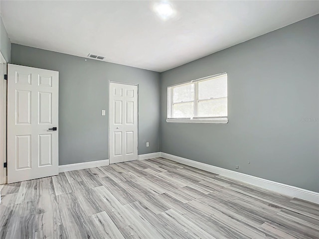 unfurnished bedroom with a closet and light wood-type flooring