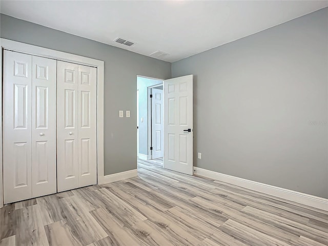 unfurnished bedroom featuring a closet and light hardwood / wood-style floors