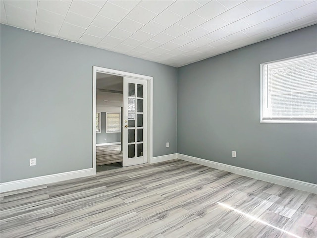 spare room with light wood-type flooring and french doors