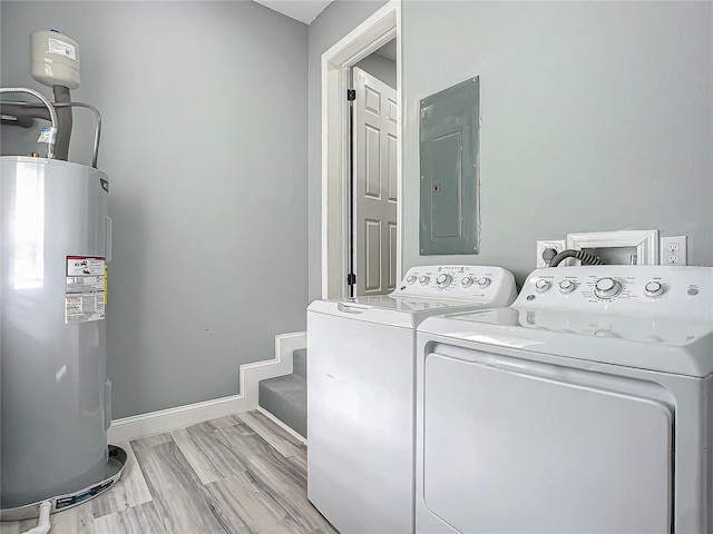 washroom with electric panel, electric water heater, washer and clothes dryer, and light hardwood / wood-style floors