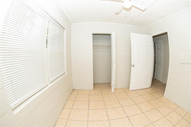 unfurnished bedroom with ceiling fan, light tile patterned floors, and a closet