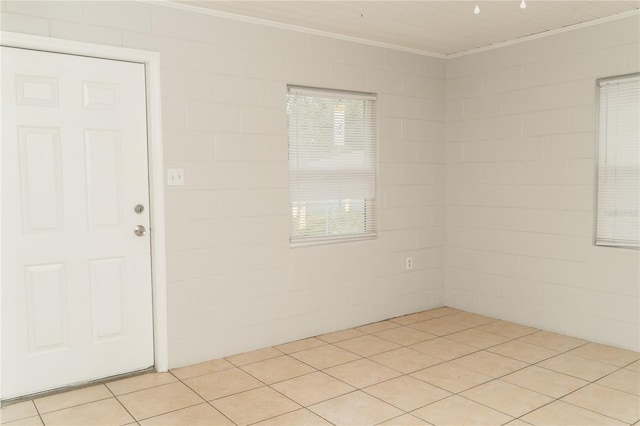 spare room featuring crown molding, plenty of natural light, and light tile patterned floors