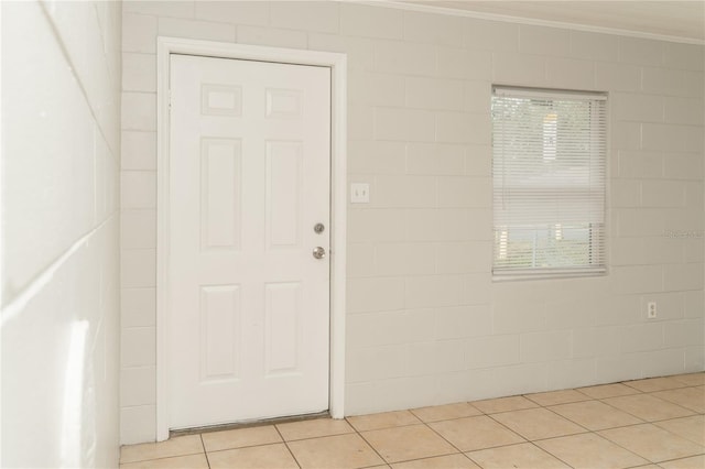 tiled entryway with a wealth of natural light and crown molding