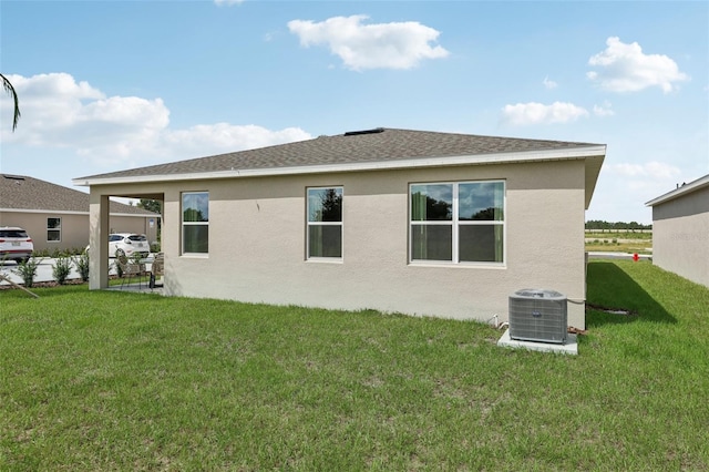 back of property with cooling unit, a patio area, and a lawn