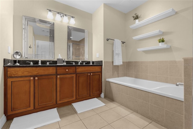 bathroom with tiled bath, tile patterned flooring, and vanity