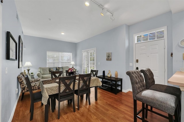 dining space featuring hardwood / wood-style floors and rail lighting