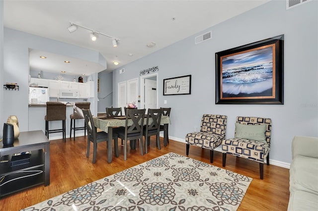 dining space featuring track lighting and light hardwood / wood-style flooring