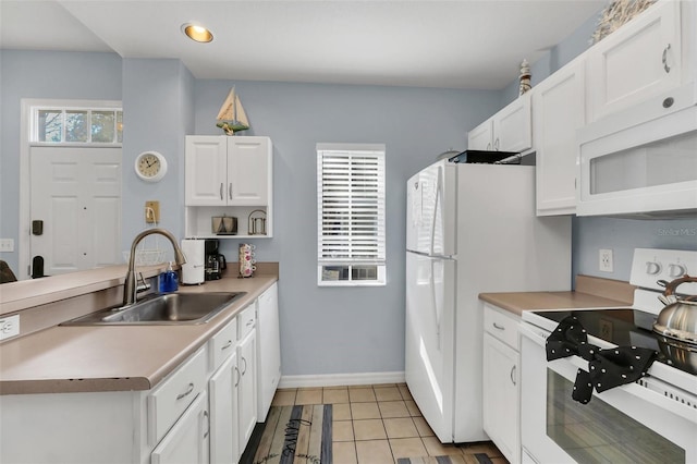 kitchen with white cabinetry, white appliances, light tile patterned flooring, and sink