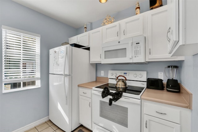 kitchen with white appliances, light tile patterned floors, and white cabinets