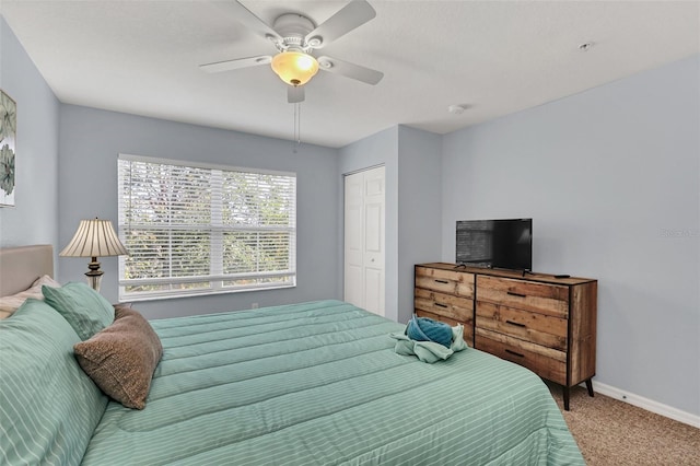 carpeted bedroom with ceiling fan and a closet