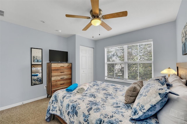 carpeted bedroom featuring ceiling fan and a closet