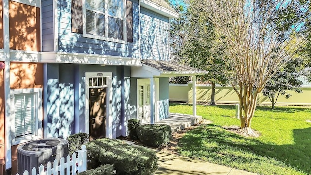 property entrance with a yard and cooling unit