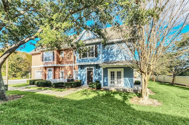 view of front of home with a front yard and french doors