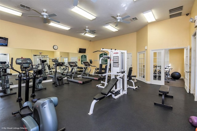 workout area with lofted ceiling, ceiling fan, french doors, and a textured ceiling