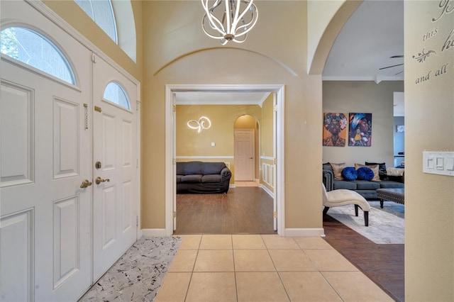 foyer entrance with light hardwood / wood-style flooring, a chandelier, and ornamental molding