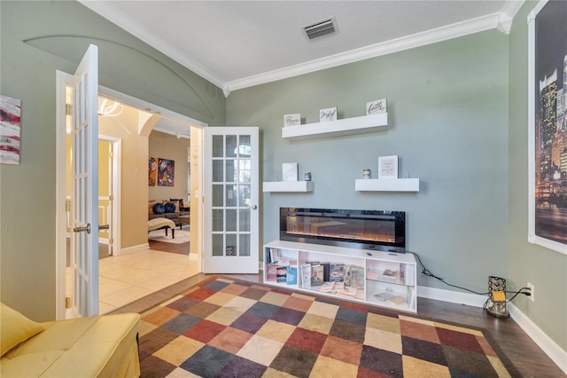 interior space with hardwood / wood-style flooring, ornamental molding, and french doors