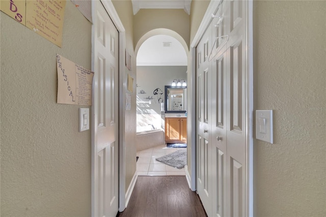 corridor with wood-type flooring and ornamental molding