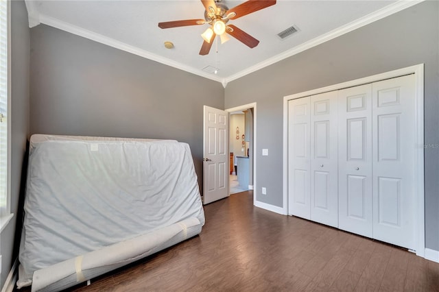 bedroom with dark hardwood / wood-style floors, ceiling fan, and crown molding