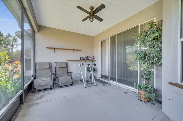 unfurnished sunroom featuring ceiling fan