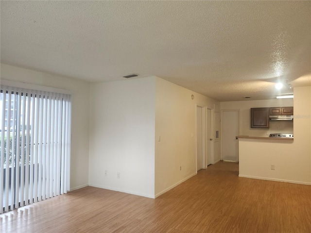 spare room with light hardwood / wood-style flooring and a textured ceiling