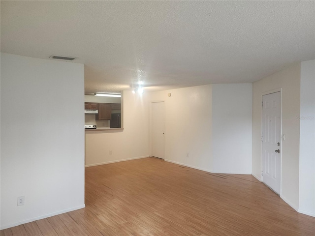 empty room featuring light hardwood / wood-style flooring and a textured ceiling