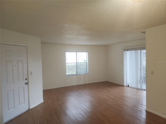 spare room with a textured ceiling and hardwood / wood-style flooring