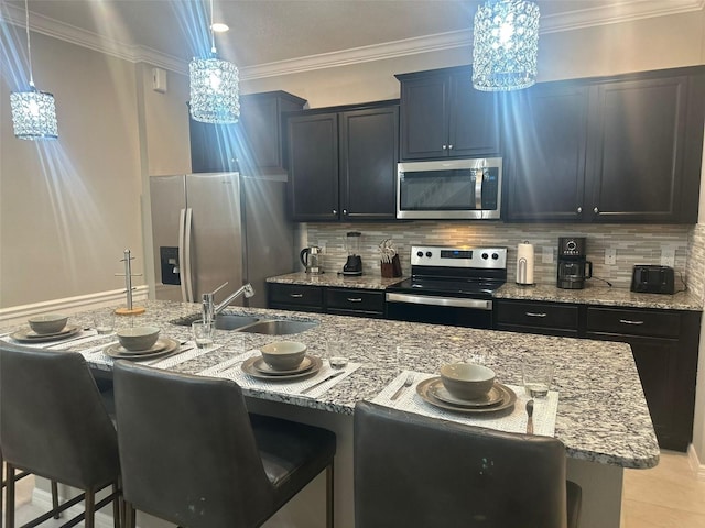 kitchen with a chandelier, sink, stainless steel appliances, and an island with sink