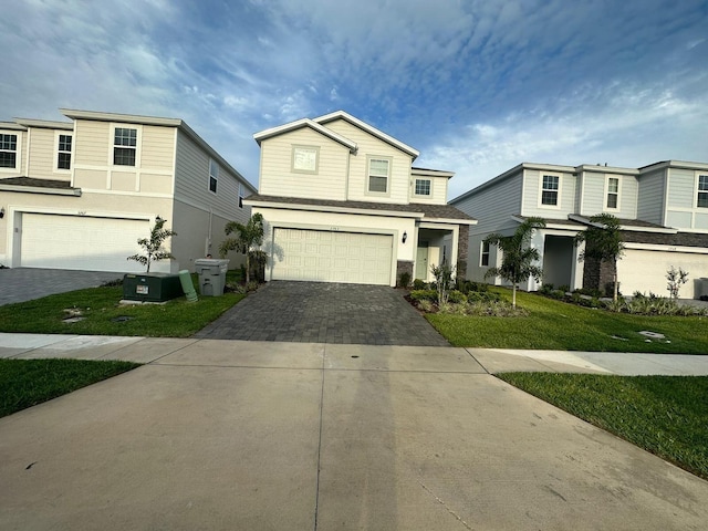 view of property featuring a garage and a front lawn