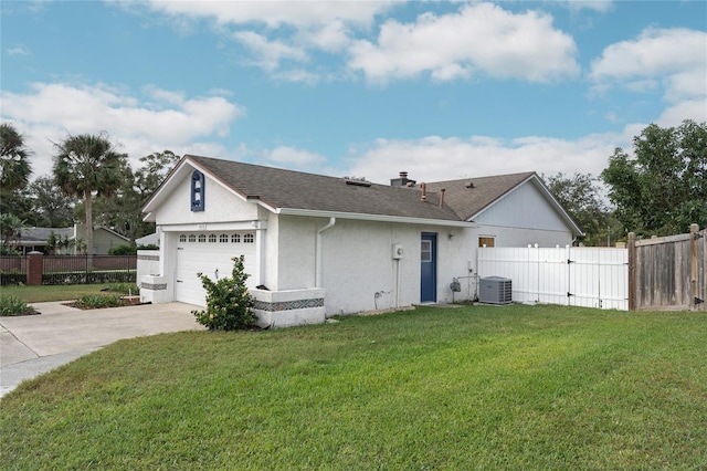 ranch-style home featuring a front lawn, a garage, and central AC unit