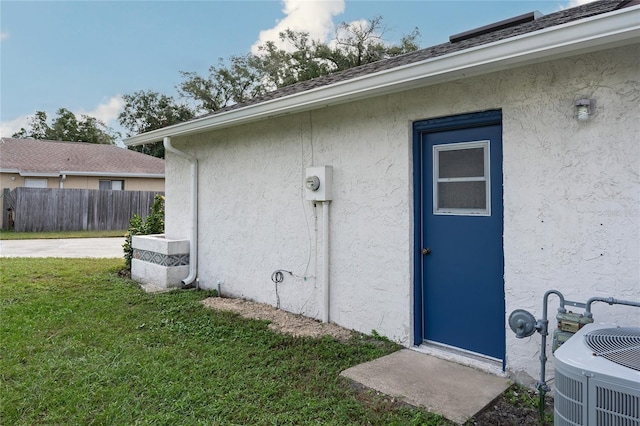 entrance to property with central AC and a yard