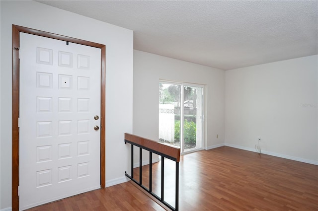 foyer entrance with wood-type flooring and a textured ceiling