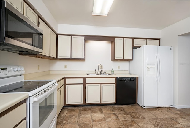 kitchen featuring cream cabinetry, white appliances, and sink