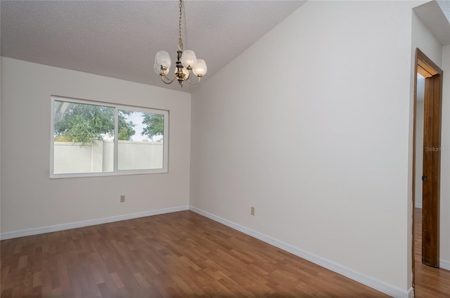 spare room with a chandelier, wood-type flooring, and a textured ceiling