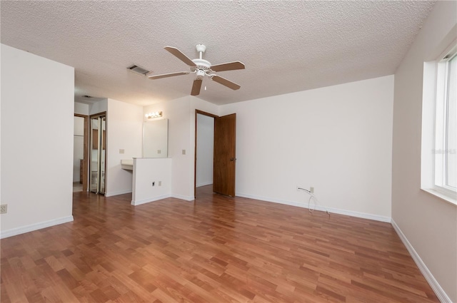 empty room with ceiling fan, hardwood / wood-style floors, and a textured ceiling