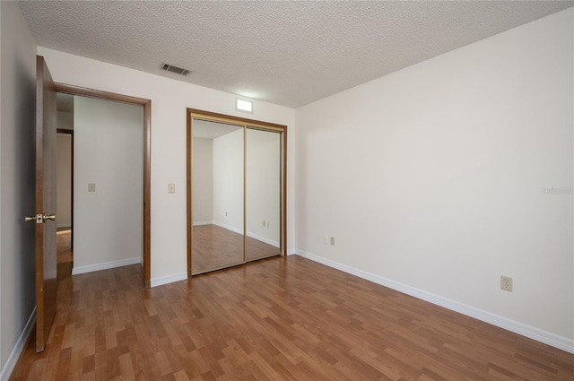 unfurnished bedroom featuring wood-type flooring and a textured ceiling