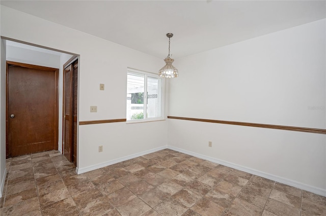 unfurnished room with a chandelier