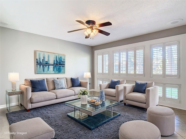 living room with a textured ceiling, tile patterned floors, plenty of natural light, and ceiling fan