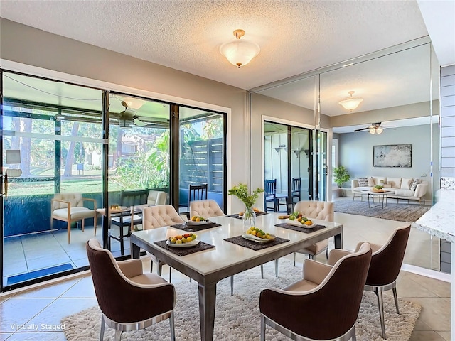 dining space featuring ceiling fan, light tile patterned flooring, and a textured ceiling