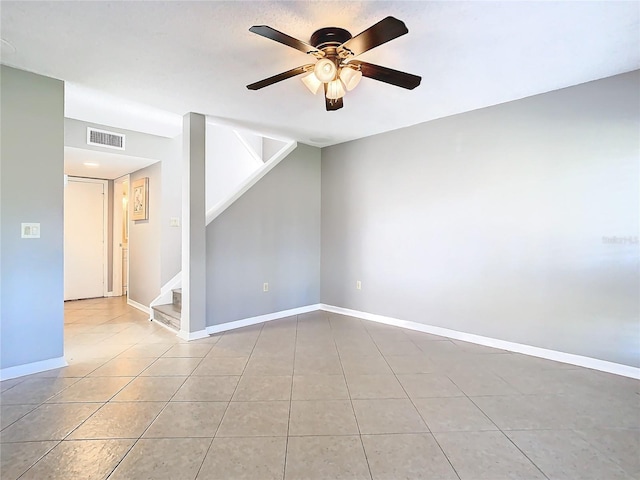 tiled spare room with ceiling fan