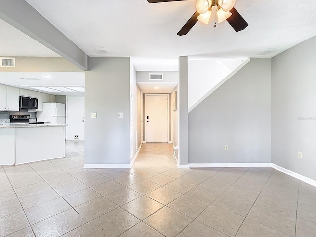 tiled empty room featuring ceiling fan