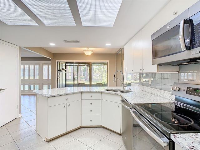 kitchen with stainless steel appliances, white cabinetry, and sink