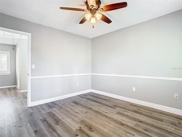 unfurnished room with ceiling fan, wood-type flooring, and a textured ceiling