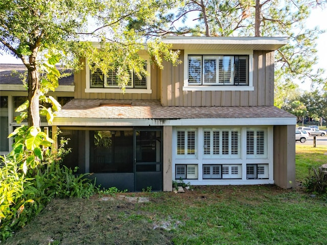 back of property featuring a sunroom and a yard