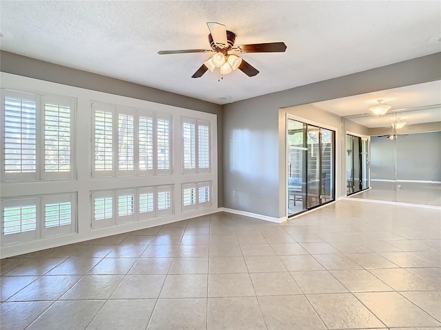 unfurnished room with a textured ceiling, ceiling fan, and light tile patterned flooring